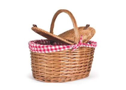 Klassischer formschöner Picknickkorb aus geflochtener Weide mit einem rot-weiß kariertem Stoff ausgeschlagen. 