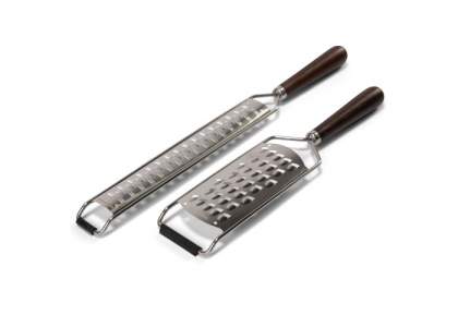 Set of two Orrefors Jernverk graters, packed in a luxury gift box. The long grater is suitable for grating e.g. cheeses and citrus fruits in fine flakes. The wide gourmet grater is very suitable for grating larger flakes. The rubber strip on the front is tilted against the surface and makes planing safe.