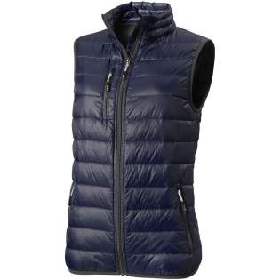 The Fairview women's lightweight down bodywarmer – perfect functionality to elevate your outdoor attire. This bodywarmer features elasticated binding on the bottom, offering a comfortable and slightly tight fit that adds protection against chilly winds. The outer shell fabric is made of nylon dull cire 20D woven with a water-repellent finish, ensuring exceptional durability and good protection against the elements. The lightweight material allows for easy movement and effortless wear throughout the day. The downproof pressed fabric prevents the down and feathers from escaping, ensuring long-lasting warmth and an extra level of durability. The down insulation is RDS certified (Responsible Down Standard), consisting of down and feathers, providing lightweight warmth without compromising ethical standards. A reliable companion for any outdoor adventure. This bodywarmer is designed with a fitted shape for a feminine look.