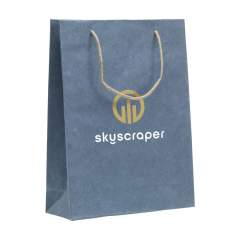 WoW! Sturdy ECO gift bag (size L) made from recycled paper with jeans fibres (180 g/m²). Due to using recycled jeans fabrics, the shade of blue can differ per bag. The blue colour gives the bag a trendy look. The bag has two short jute carrying loops, a folded bottom and a side fold. Suitable for all kinds of promotional purposes. No trees are cut down for the production of this bag.