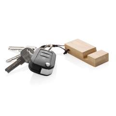 FSC® 100-zertifizierter Bambus-Schlüsselanhänger mit Telefonständer. Mit Stoffseil und Metallschlüsselring. Praktisch, damit Sie immer einen Telefonständer bei sich haben, wenn Sie einen Anruf tätigen oder einen Film ansehen wollen. Verpackt in plastikfreier Umschlagverpackung.