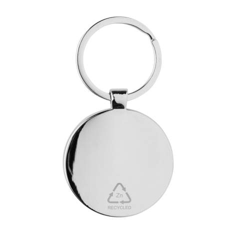 Ronde sleutelhanger gemaakt van RCS-gerecycled zinc alloy en bamboe. Totaal gerecycled materiaal: 73% op basis van het totale gewicht van het item. RCS-certificering zorgt voor een volledig gecertificeerde toeleveringsketen van de gerecyclede materialen. Verpakt in papieren zak