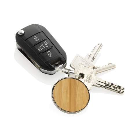 Ronde sleutelhanger gemaakt van RCS-gerecycled zinc alloy en bamboe. Totaal gerecycled materiaal: 73% op basis van het totale gewicht van het item. RCS-certificering zorgt voor een volledig gecertificeerde toeleveringsketen van de gerecyclede materialen. Verpakt in papieren zak