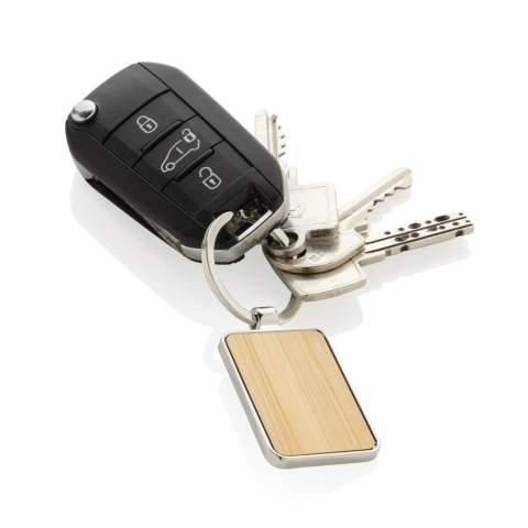 Ronde sleutelhanger gemaakt van RCS-gerecycled zinc alloy en bamboe. Totaal gerecycled materiaal: 76 % op basis van het totale gewicht van het item. RCS-certificering zorgt voor een volledig gecertificeerde toeleveringsketen van de gerecyclede materialen. Verpakt in papieren zak.