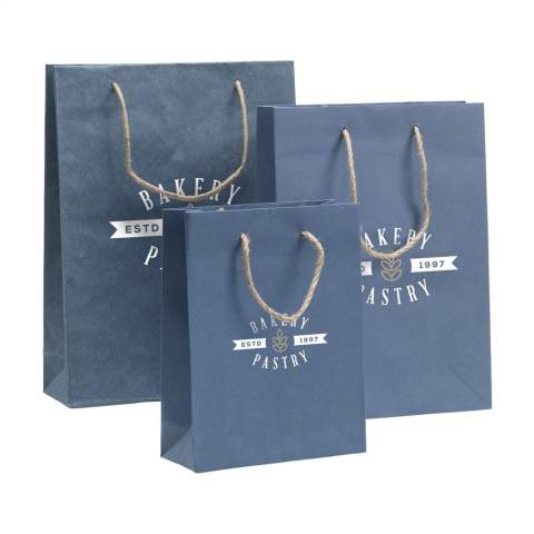 WoW! Sac cadeau robuste (taille L) en papier recyclé avec fibres de jeans (180 g/m²). En raison de l'utilisation de tissus de jeans recyclés, la nuance de bleu peut différer d'un sac à l'autre. La couleur bleue donne au sac un look tendance. Le sac est doté de deux poignées de transport courtes en jute, d'un fond plié et d'un pli latéral. Convient à toutes sortes de fins promotionnelles. Aucun arbre n'a été abattu pour la production de ce sac.
