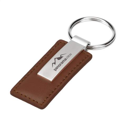 Mattmetallener Schlüsselanhänger mit stabilem Schlüsselring, kombiniert mit Imitatleder. Wird einzeln in einem Umschlag aus Kraftpapier geliefert.