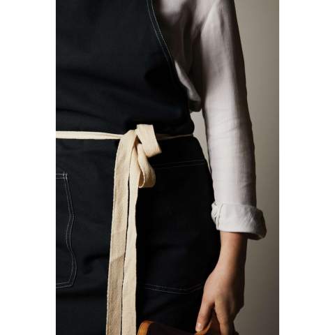 Apron made from 70% certified recycled cotton from suppliers' cotton waste. Fibres that are usually considered unusable have, with the appropriate manufacturing process, achieved the desired properties. This apron is extra wide to provide maximum protection. Two large front pockets and a loop for hanging utensils or a tea towel.