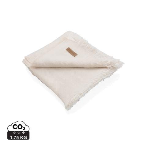 Couverture 130x150cm Ukiyo Aware™ Polylana® tissée avec des bords frangés. Gardez-la sur votre canapé pour des soirées cinéma douillettes ou sur votre lit pour un beau look. Avec le traceur AWARE™ qui valide l'utilisation authentique de matériaux recyclés. 2 % du produit de la vente de chaque produit contenant AWARE™ sera reversé à Water.org.