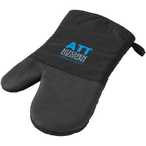 Manique pour droitier avec grip en silicone et motif à carreaux sur l'autre côté. L'ouverture de la manique est de 14 cm.