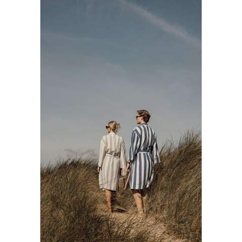 Neem deze zachte en comfortabele hamam badjas mee naar het strand of geniet er gewoon thuis van. Hij is gemaakt van een lichtgewicht en luchtige 200 grams mix en combineert het comfort van katoen met de sneldrogende voordelen van polyester. Ontworpen in een klassieke stijl met een tweekleurig gestreept patroon en voorzien van een nette kraag, voorzakken, 3/4 mouwen en een tailleband voor een perfecte pasvorm. Gecertificeerd door GRS (Global Recycled Standard), GRS certificering garandeert dat de hele toeleveringsketen van de gerecyclede materialen gecertificeerd is. De totale gerecyclede inhoud is gebaseerd op het totale productgewicht. Dit product bevat 69% GRS-gecertificeerd gerecycled katoen en 29% GRS-gecertificeerd gerecycled polyester.
