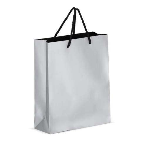 Elegante Geschenktasche aus FSC-zertifiziertem Papier mit 5 mm dicken Kordeln aus recyceltem Polyester. Sie ist für ein Gewicht von bis zu 5 kg ausgelegt und hat ein luxuriöses Aussehen mit schwarzen Griffen und einer schwarzen Innenseite. Perfekt zum Überreichen von Geschenken.
