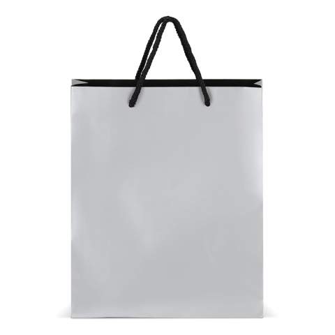 Elegante Geschenktasche aus FSC-zertifiziertem Papier mit 5 mm dicken Kordeln aus recyceltem Polyester. Sie ist für ein Gewicht von bis zu 5 kg ausgelegt und hat ein luxuriöses Aussehen mit schwarzen Griffen und einer schwarzen Innenseite. Perfekt zum Überreichen von Geschenken.
