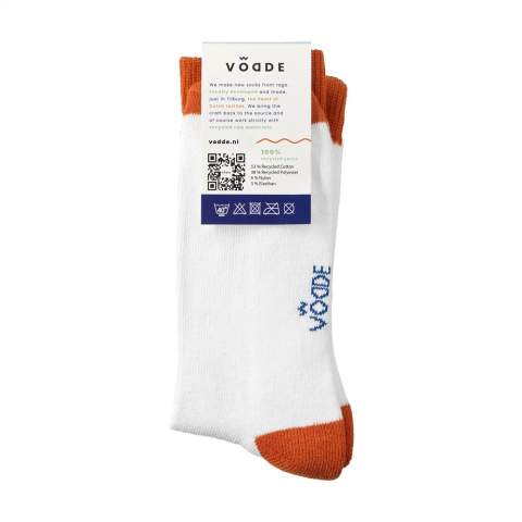 Comfortable socks from Vodde made using a 100% circular economy manufacturing process. These socks are made from collected textiles. The socks consist of 53% recycled cotton (from collected pieces of fabric), 38% recycled polyester (from collected PET bottles), 6% nylon and 3% elastane. Including knitted-in, customised design. All Vodde socks are supplied as standard in pairs with a label, which can be printed in your own full color design. This way you can design your own socks that perfectly match any corporate identity. These quality socks have a reinforced sole and are ideal to wear during sports or hiking.   • Available in sizes M (36-40) and L (41-46). • Minimum order: 100 pairs of socks per size. Minimum order in total: 200 pairs of socks.  • Optional:  Supplied in pairs in a (customised) box made from recycled  cardboard - possible from 1,200 pairs of socks.   • By wearing these socks you are contributing to a sustainable world with less pollution. Developed and tested in the Netherlands. Made in the EU.  • The Dutch company Vodde reuses discarded textiles to make new products designed by Dutch designers. Vodde makes its yarn from cotton collected by local 'rag farmers' and from cutting waste from textile production in European countries where Vodde makes its own products. In addition, polyesters derived from PET bottles, nylon, fishing nets and other collected waste are also used.