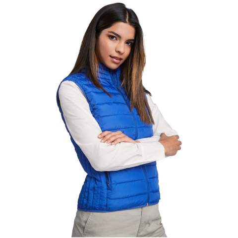 Feather touch gilet vest for women. Matching inverted zips. Two front pockets with zip. Contrasting inner lining. Matching elastic trim in hem. Stow carry bag included. Light and foldable garment. Fitted cut. Water resistant. Wind-proof model. The model is 174 cm and is wearing size S.