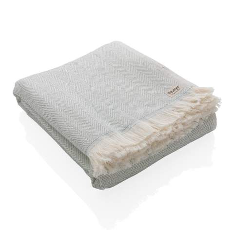 Our most luxurious and versatile towel. The perfect travel companion in any circumstance.  This towel contains 22% recycled cotton and is super soft and silky to the touch. With AWARE™ tracer that validates the genuine use of recycled cotton. You can use it for almost anything, such as the beach, travelling, sauna, swimming pool, camping, sports, as a beach towel, bath towel, scarf, pareo, yoga towel, blanket, as a wrap for your child - you name it. Perfect for sofas and dressing beds, the Hisako throws are also wonderful for sunbathing on or using as a machine-washable picnic blanket. These four seasons hammam towels are quick-drying, mould resistant and incredibly easy to clean making them a brilliant choice for allergy sufferers, red wine lovers and beachgoers. 2% of proceeds of each Impact product sold will be donated to Water.org. Machine washable. Made in Portugal.