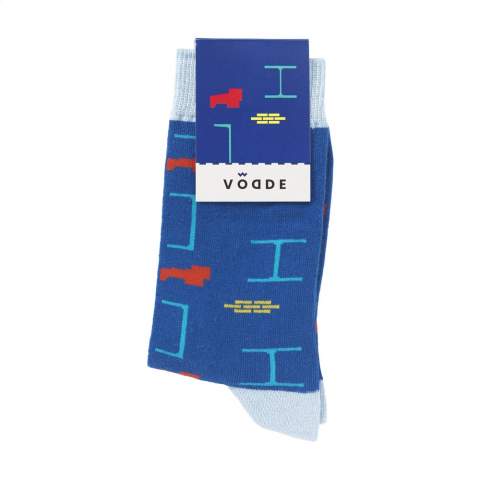 Bequeme, 100% zirkuläre Socken der Marke Vodde. Die Socken bestehen zu 53% aus recycelter Baumwolle (gesammelte Stofflappen), zu 38% aus recyceltem Polyester (aus gesammelten PET-Flaschen), 6% aus Nylon und zu 3% aus Elasthan. Inklusive eingestricktem, individuellem Design. Die Socken sind standardmäßig mit einem Etikett aneinander befestigt, das in Ihrem eigenen, vollfarbigen Design bedruckt werden kann. So entwerfen Sie Ihre eigenen Socken, die perfekt zu Ihrem Corporate Design und Ihren Wünschen passen. Diese dünnen Qualitätssocken für den täglichen Gebrauch sind perfekt, um sie mit einem Freizeit-Outfit zu kombinieren.   • Erhältlich in den Größen M (36-40) und L (41-46). • Mindestbestellmenge: 100 Paar Socken pro Größe. Mindestbestellmenge insgesamt: 200 Paar Socken.   • Optional: Lieferung paarweise in einer (individuell gestalteten) Schachtel aus recyceltem Karton - ab 1.200 Paar Socken möglich.   • Wenn Sie diese umweltfreundlichen Socken tragen, leisten Sie einen Beitrag zu einer nachhaltigen Welt mit weniger Umweltverschmutzung. Entwickelt und getestet in den Niederlanden. Made in the EU.   • Der Sockenfuß besteht aus recyceltem Garn und wird in einer Standardfarbe geliefert. Sie können aus 21 Standardfarben von recyceltem Garn wählen. Jedes Design in der Basis, der Manschette, der Ferse und der Spitze kann in jeder Farbe Ihrer Wahl realisiert werden.   • Das niederländische Unternehmen Vodde recycelt ausrangierte Textilien und stellt daraus neue Produkte her, die von niederländischen Designern entworfen werden. Vodde stellt seine Garne aus Baumwolle her, die von lokalen „Lumpenhändlern“ gesammelt wird, sowie aus Abfällen von Textilproduktionen in europäischen Ländern, in denen Vodde seine eigenen Produkte herstellt. Darüber hinaus werden Polyester aus PET-Flaschen, Nylon, Fischernetzen und anderen gesammelten Abfällen verwendet.
