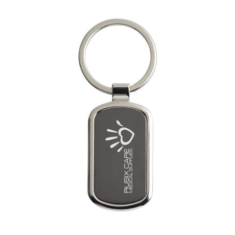 Rechthoekige, hoogglans, nikkelen sleutelhanger met zwart metalen inlay en stevige sleutelring. Chic en exclusief. Per stuk in kraft envelop.