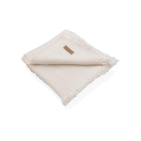 Couverture 130x150cm Ukiyo Aware™ Polylana® tissée avec des bords frangés. Gardez-la sur votre canapé pour des soirées cinéma douillettes ou sur votre lit pour un beau look. Avec le traceur AWARE™ qui valide l'utilisation authentique de matériaux recyclés. 2 % du produit de la vente de chaque produit contenant AWARE™ sera reversé à Water.org.