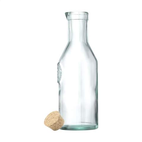 WoW! Decorative water bottle with spout made from 100% robust recycled quality glass. Closes with a cork cap. The glass is embossed with the 'Authentic Glass 100% recycled' label. The blue-green tint of this glass is a natural result of the recycling process. The colour and any imperfections emphasise the beauty of this recycled product and contributes to its authenticity. Recycling reduces the consumption of new raw materials, water and energy. Colour, thickness and size may vary by product. Made in Spain. Capacity 1,200 ml.