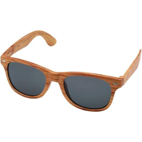Zonnebril met retrodesign en afwerking in houtlook. Deze zonnebril met UV 400-lenzen is geclassificeerd als categorie 3, waardoor ze de perfecte keuze zijn voor bescherming tegen fel zonlicht. Voldoet aan EU-veiligheidsnorm EN12312-1. Het PC plastic zorgt ervoor dat het product licht buigbaar is voor comfort.