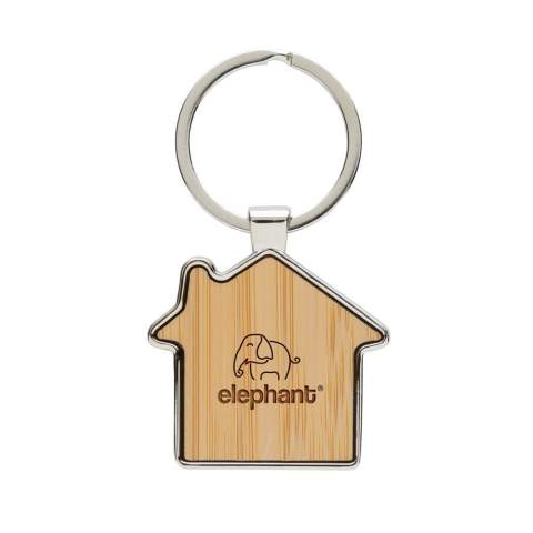 Porte-clés en forme de maison en alliage de zinc recyclé RCS et bambou. Contenu recyclé total : 76% sur la base du poids total de l'article. La certification RCS garantit une chaîne d'approvisionnement entièrement certifiée pour les matériaux recyclés. Emballé dans un sachet en papier.