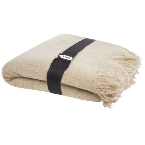 Ultrazachte GRS gerecyclede deken, omwikkeld met een 190T RPET-lint. Verpakt in een gerecyclede polybag. Lengte franjes: 10 cm aan elke kant. Afmetingen lint: 72 cm x 4 cm.